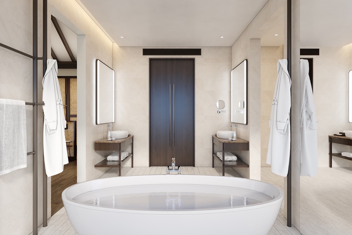 Spacious bathroom with oval soaking tub, dual vanities with mirrors, and dark wood cabinetry at Anantara Veli Maldives Resort.