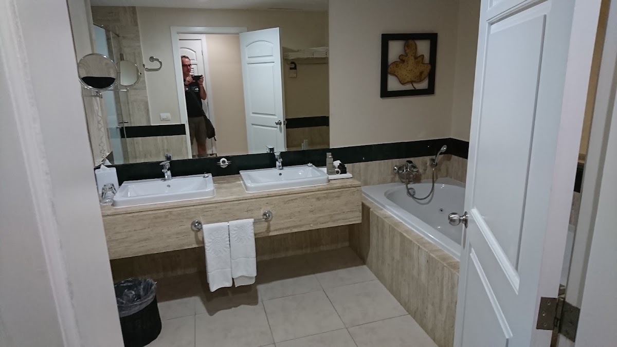 Spacious bathroom with dual sinks, black-trimmed mirror, and soaking tub at Bahia Principe Explore Akumal.