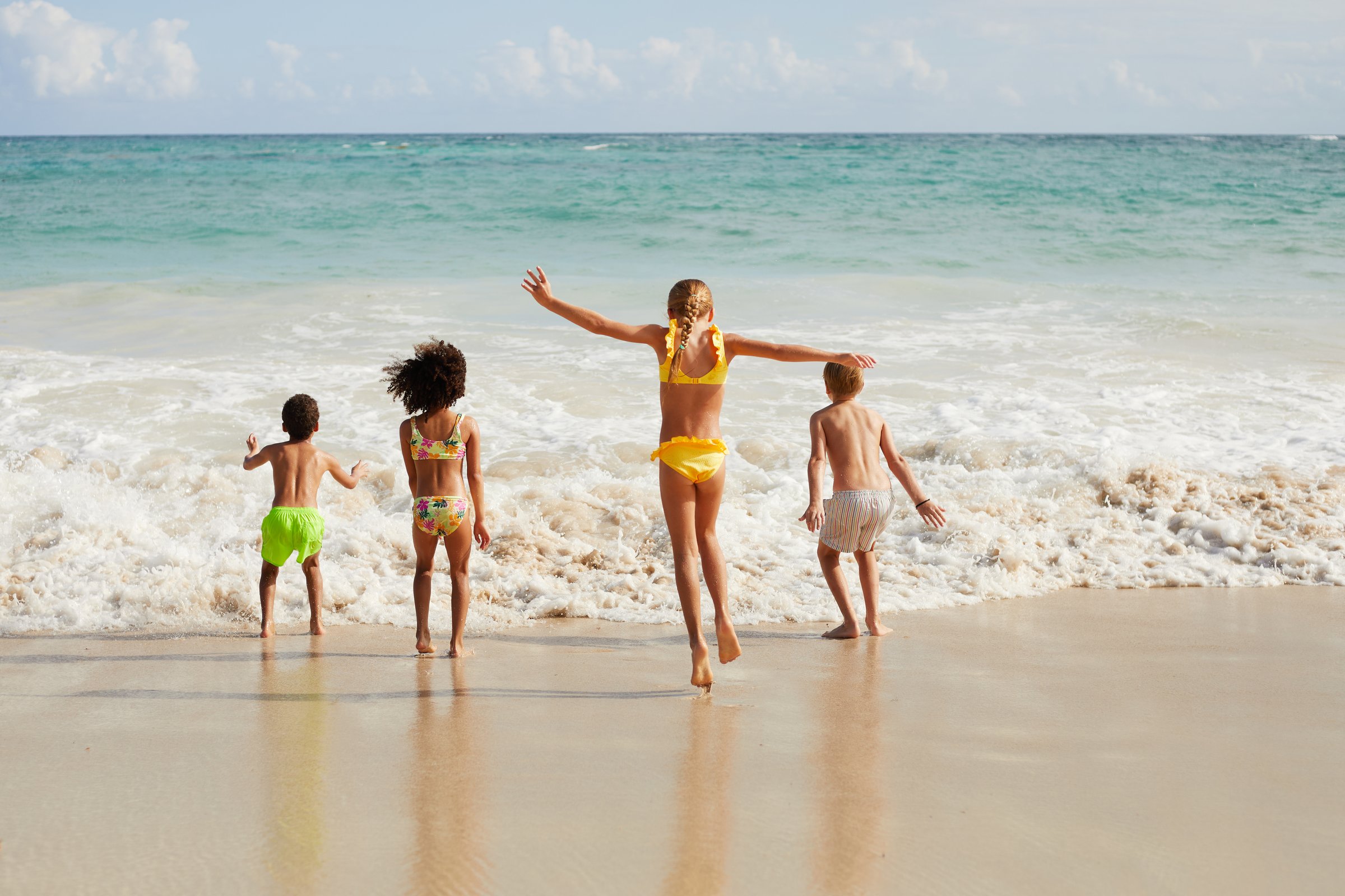 Children playing at the water's edge on the beach
