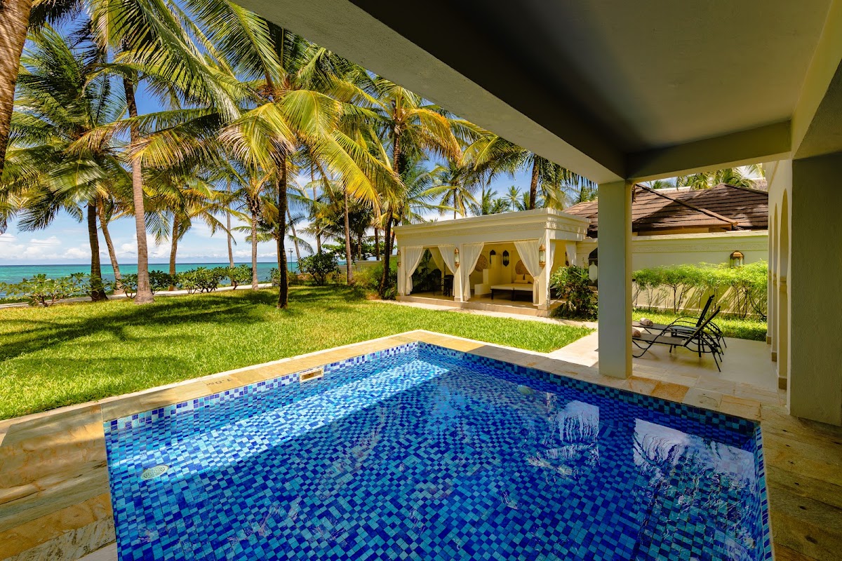 Private villa pool with turquoise ocean and palm trees beyond at Baraza Resort & Spa.