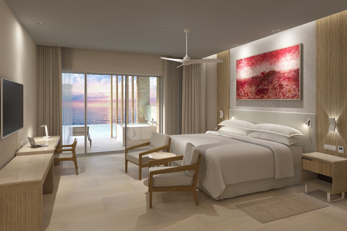 Modern resort bedroom with white bedding, wood accents, ocean view through glass doors, and red abstract artwork above the bed.