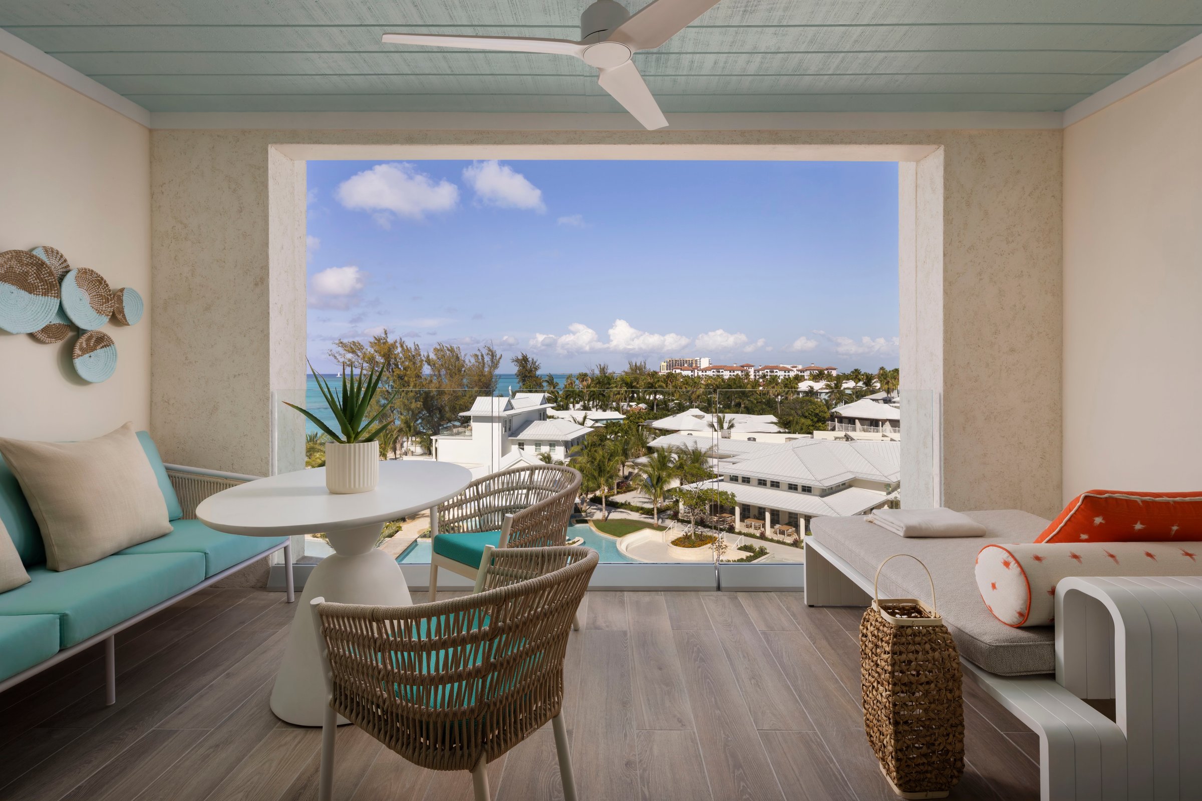 Suite patio with wicker seating looking over the village and sea.