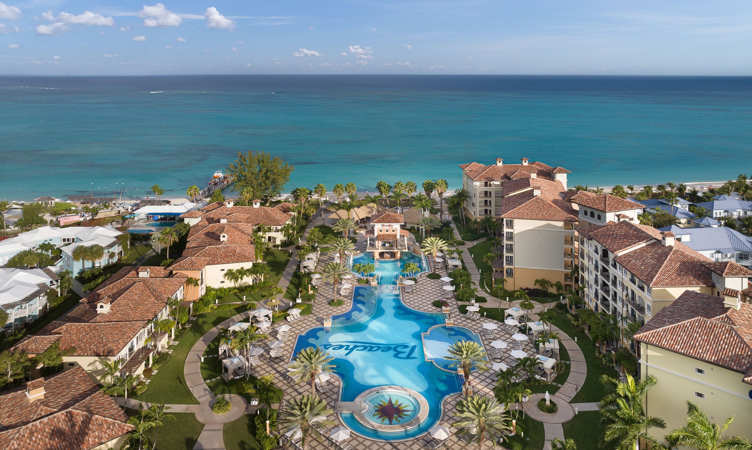 Aerial of the Italian Village pool and piazza with the ocean beyond.