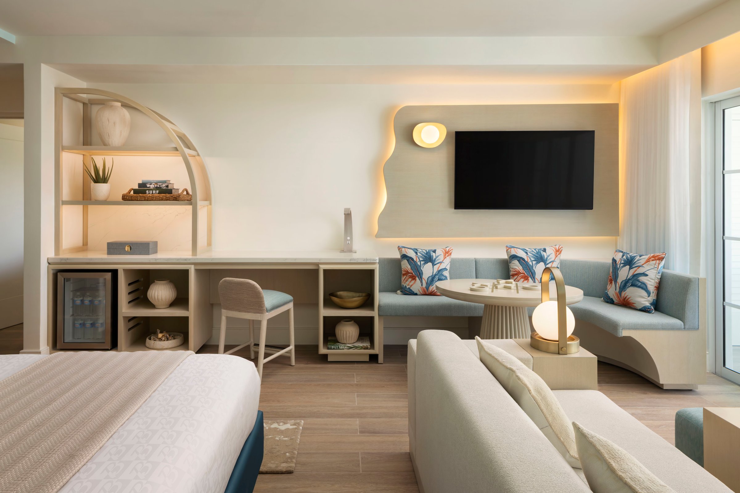Modern suite with a lounge area, built-in shelves and soft lighting.