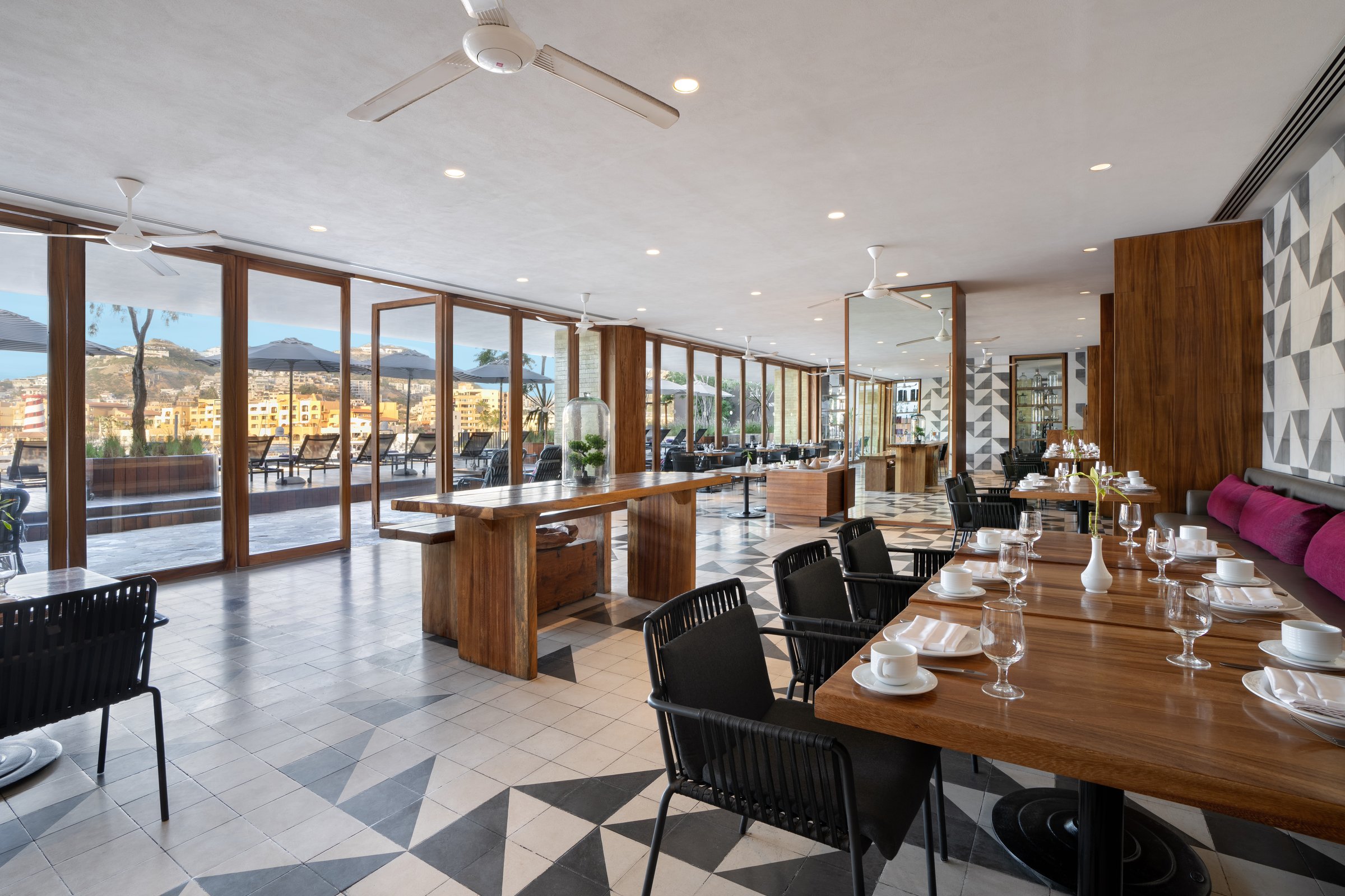 Bites restaurant with geometric black and white floor tiles, wooden tables, dark chairs and large windows onto the marina.