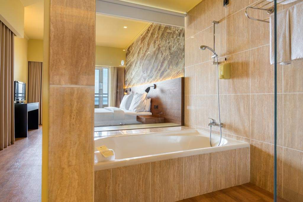 Bathroom with soaking tub and walk-in shower at Calheta Beach - All Inclusive - Savoy Signature, with view to bedroom beyond.