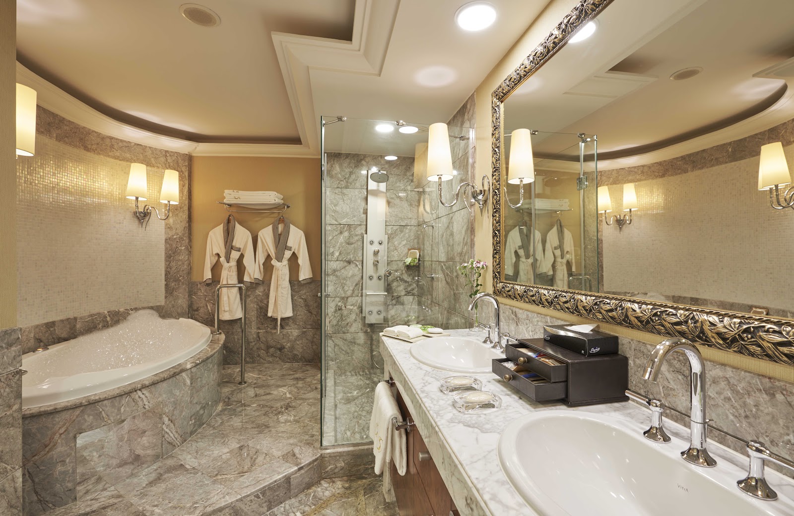 Spacious resort suite with cream and burgundy seating, glass coffee table, wooden flooring, and floor-to-ceiling windows overlooking the grounds at Calista Luxury Resort.