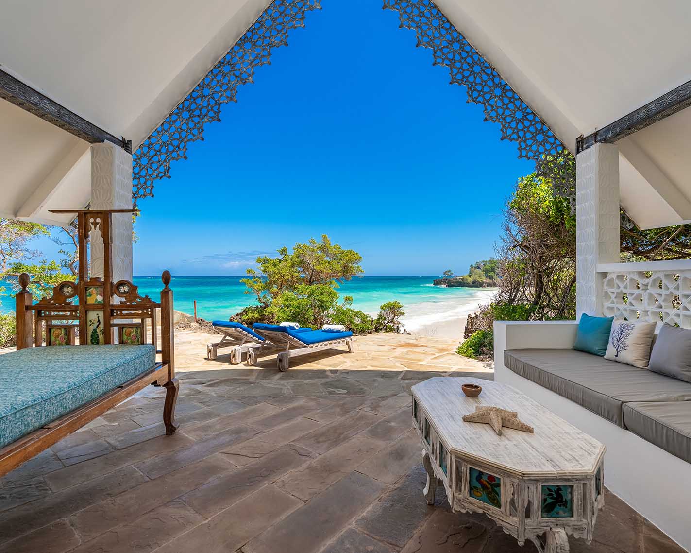 Curved infinity pool with turquoise water surrounded by dense mangrove trees and stone deck with metal railings at Chale Island Resort.