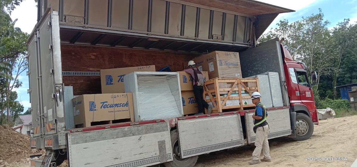 Workers unload cardboard boxes and supplies from an open truck bed at Club Med Borneo.