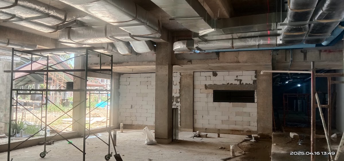 Unfinished interior space with concrete pillars, exposed ducts, and cinder block walls under construction at Club Med Borneo.