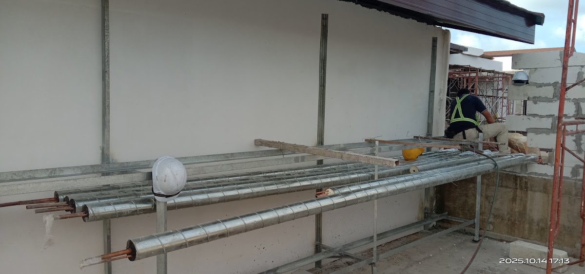 Construction site with metal ductwork and white concrete walls under development at Club Med Borneo.