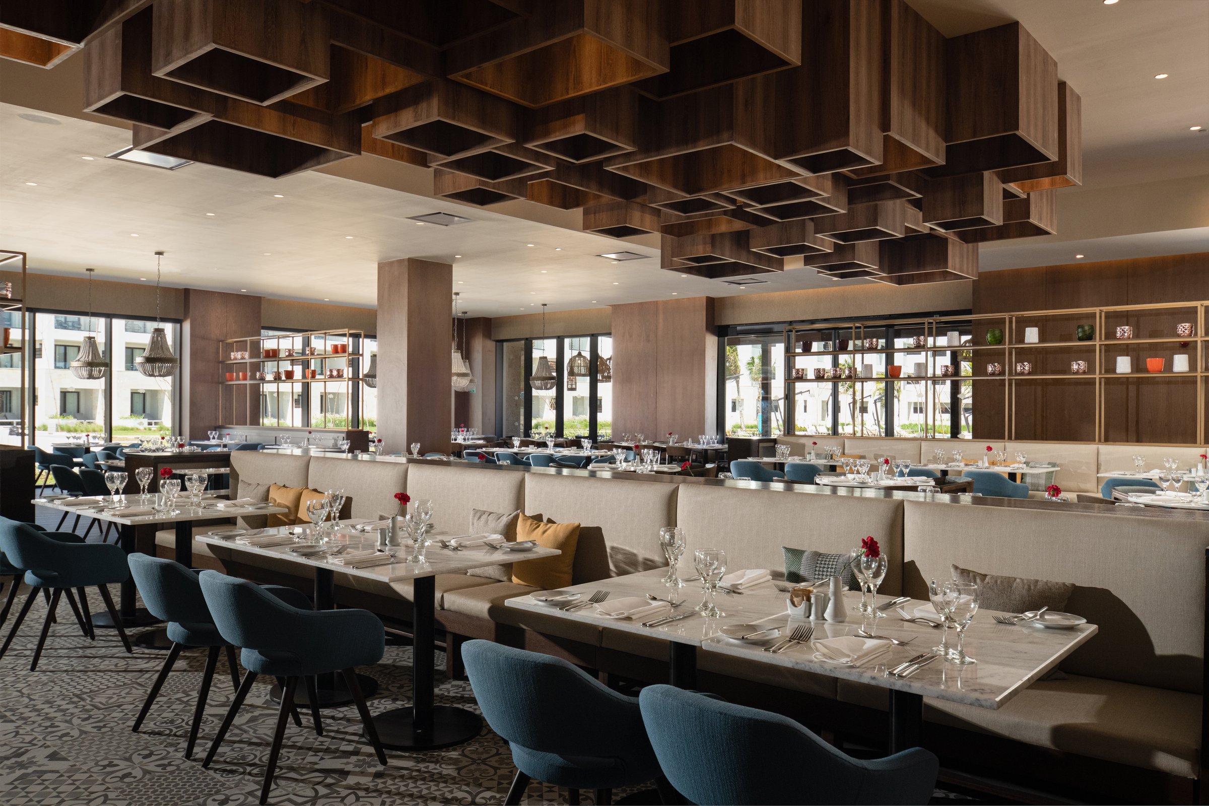World Cafe dining room with banquettes and a wooden box-grid ceiling.
