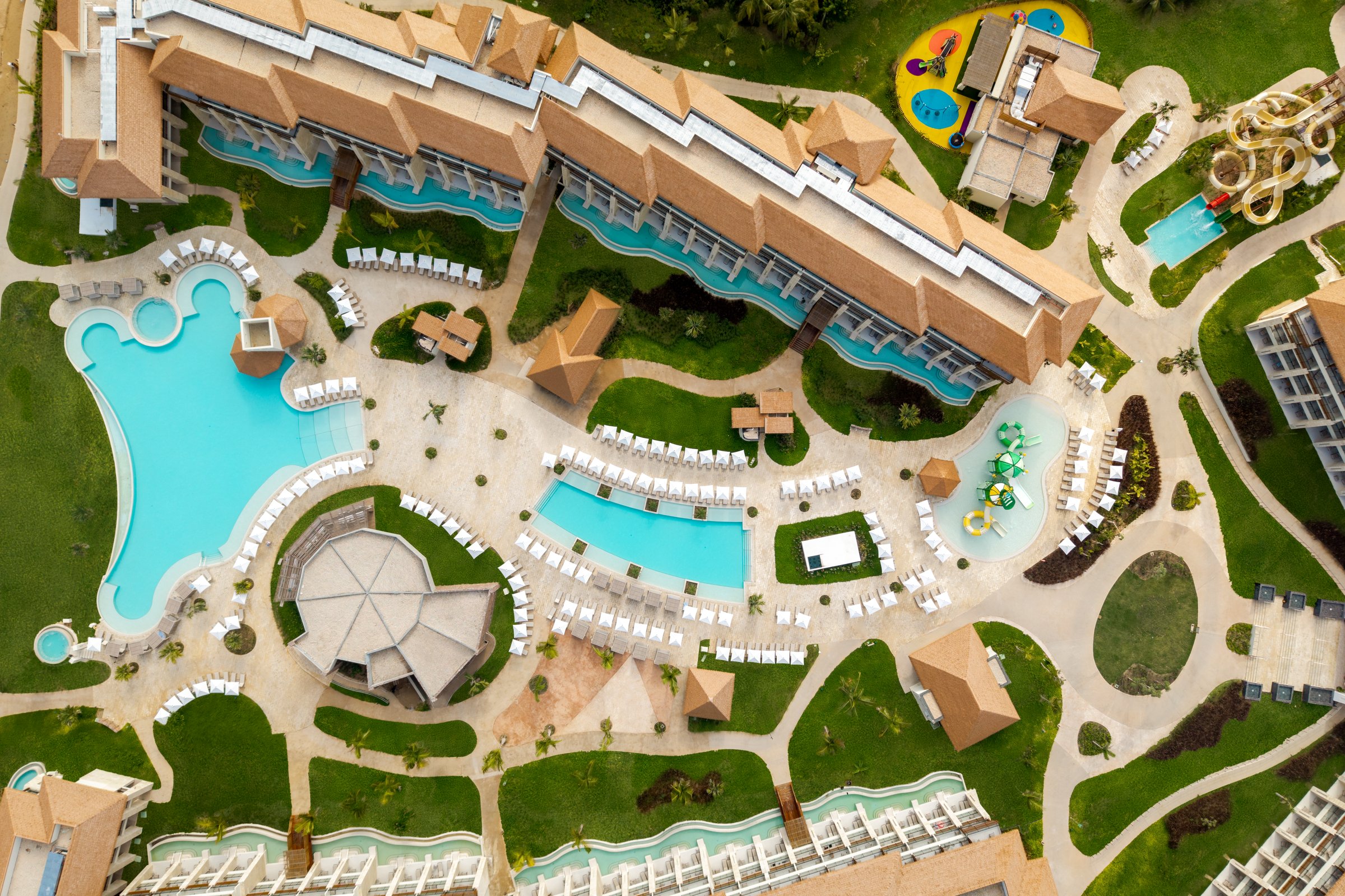 Overhead view of the guest wing, pools and splash pad with manicured lawns.