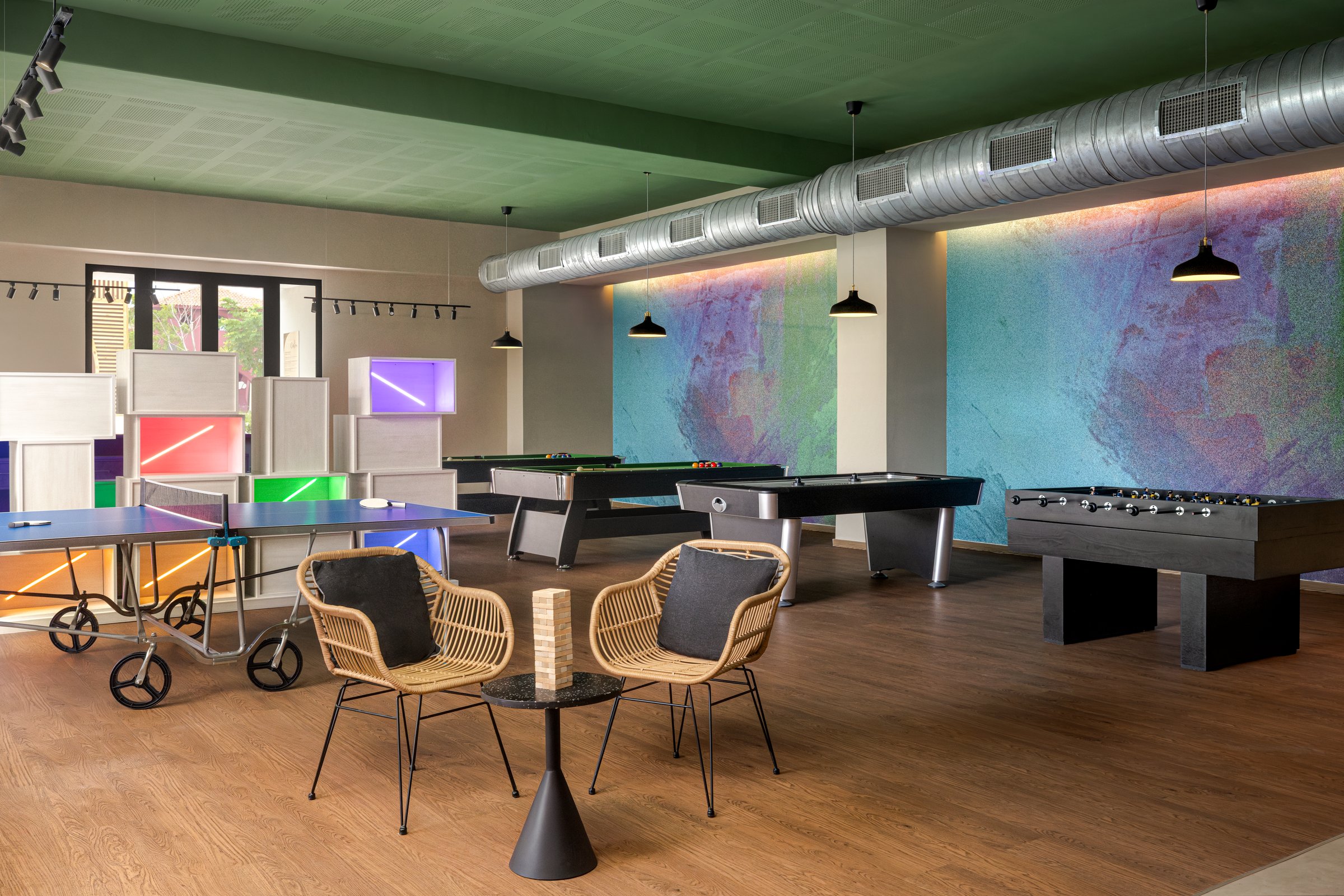 Core Zone game room with ping-pong, pool tables, foosball and colourful wall panels.