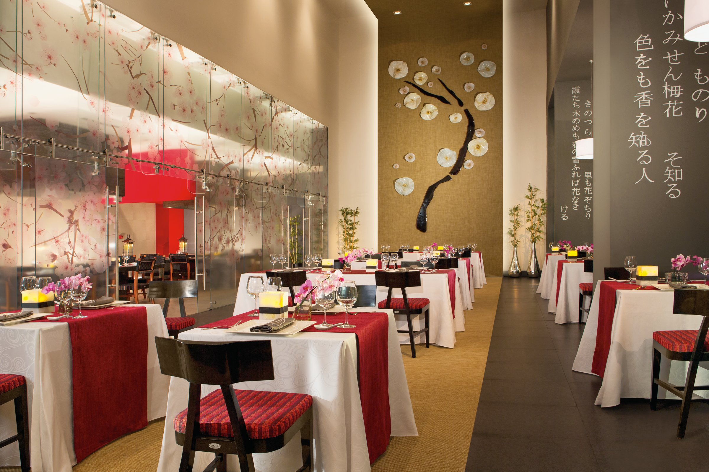Himitsu dining room with cherry-blossom glass mural and gold tree artwork.