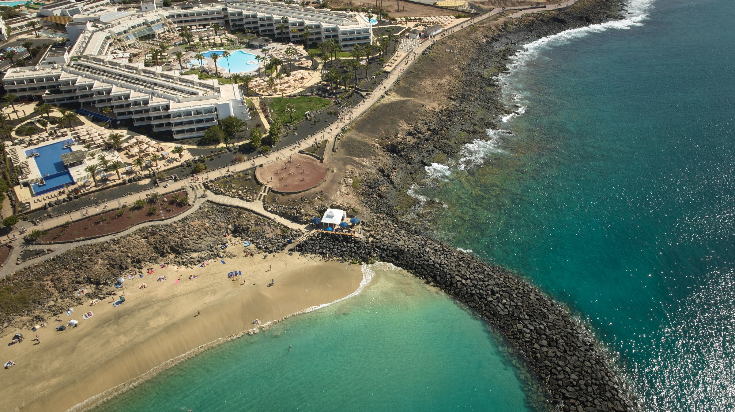 Aerial view of the resort's cove beach and rocky shoreline