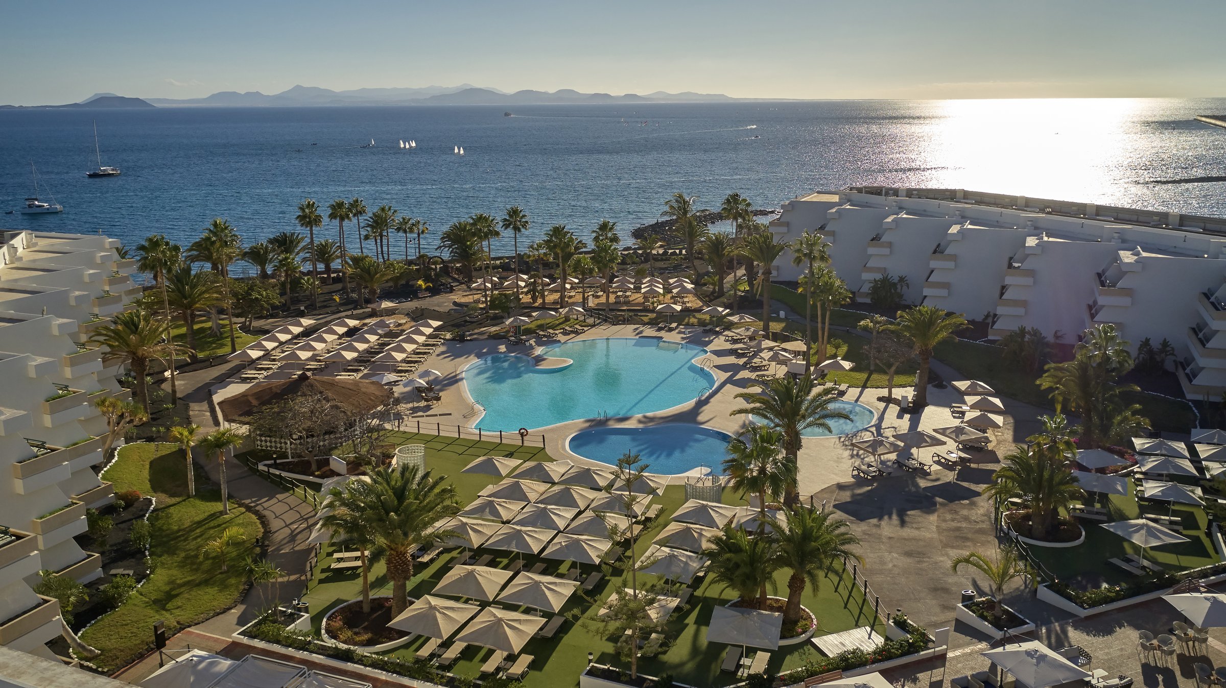 Aerial view over the resort pools toward the ocean