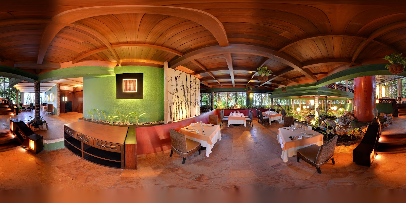 Dining table with plates and drinks overlooking turquoise Caribbean water and sandy beach at Grand Park Royal Cancún.