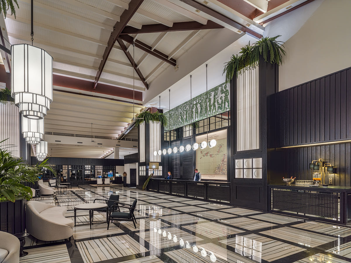 Spacious lobby with high ceilings, dark wood beams, hanging plants, and a black-and-white geometric floor at H10 Rubicón Horizons Collection.
