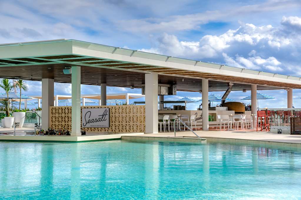 Turquoise pool in front of the Casali beachfront restaurant at Hilton Cancun Mar Caribe, with ocean view and white columns.