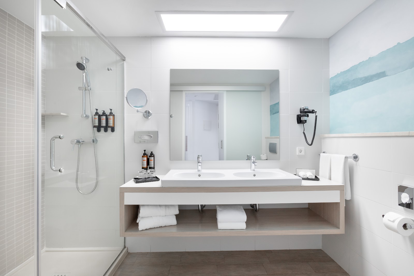 Modern bathroom with dual sinks, walk-in shower, and amenities at Hotel Riu Gran Canaria.