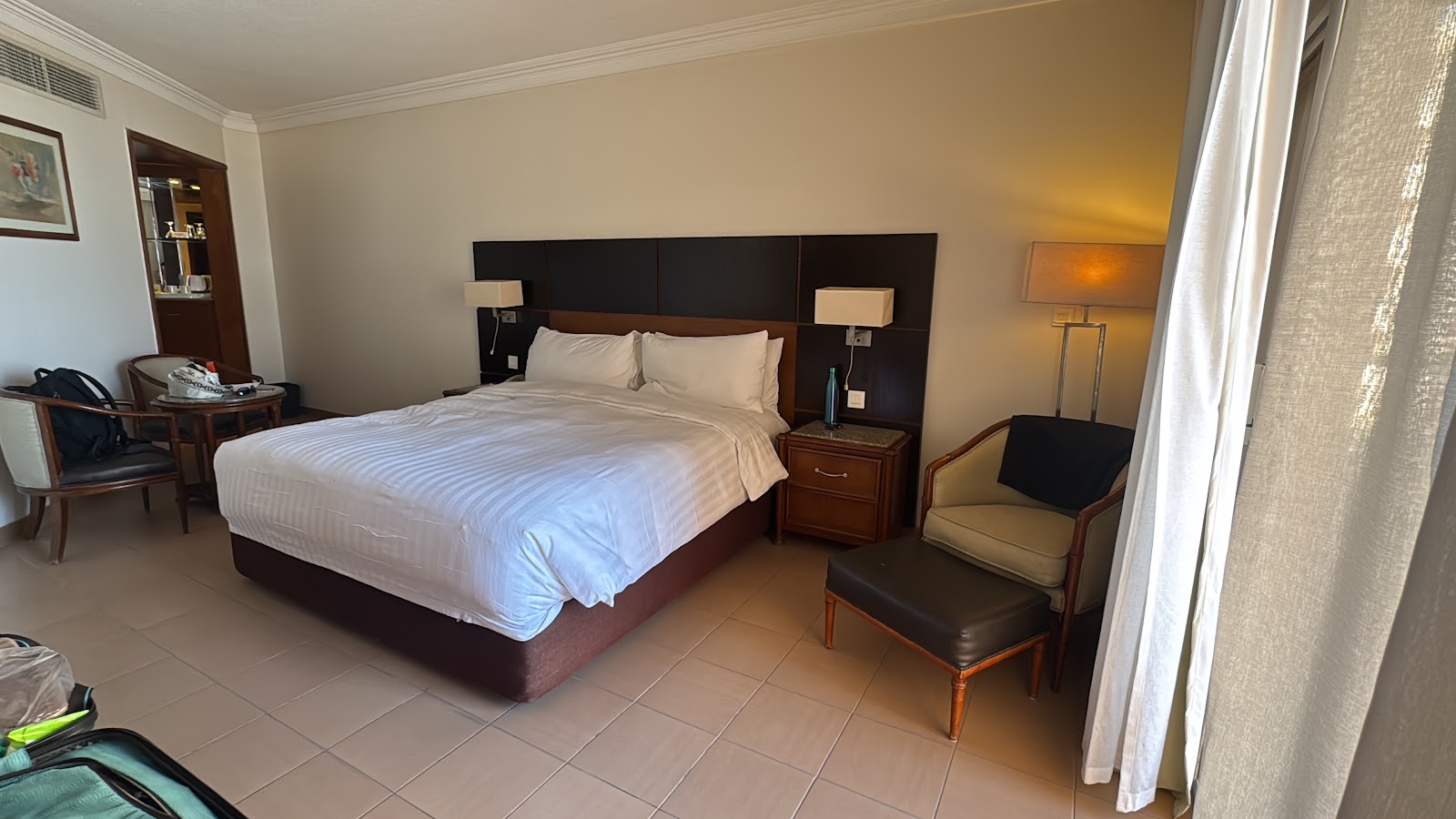View from a beachfront room showing an unmade bed in foreground and open glass doors leading to a balcony overlooking the Red Sea and resort beach.
