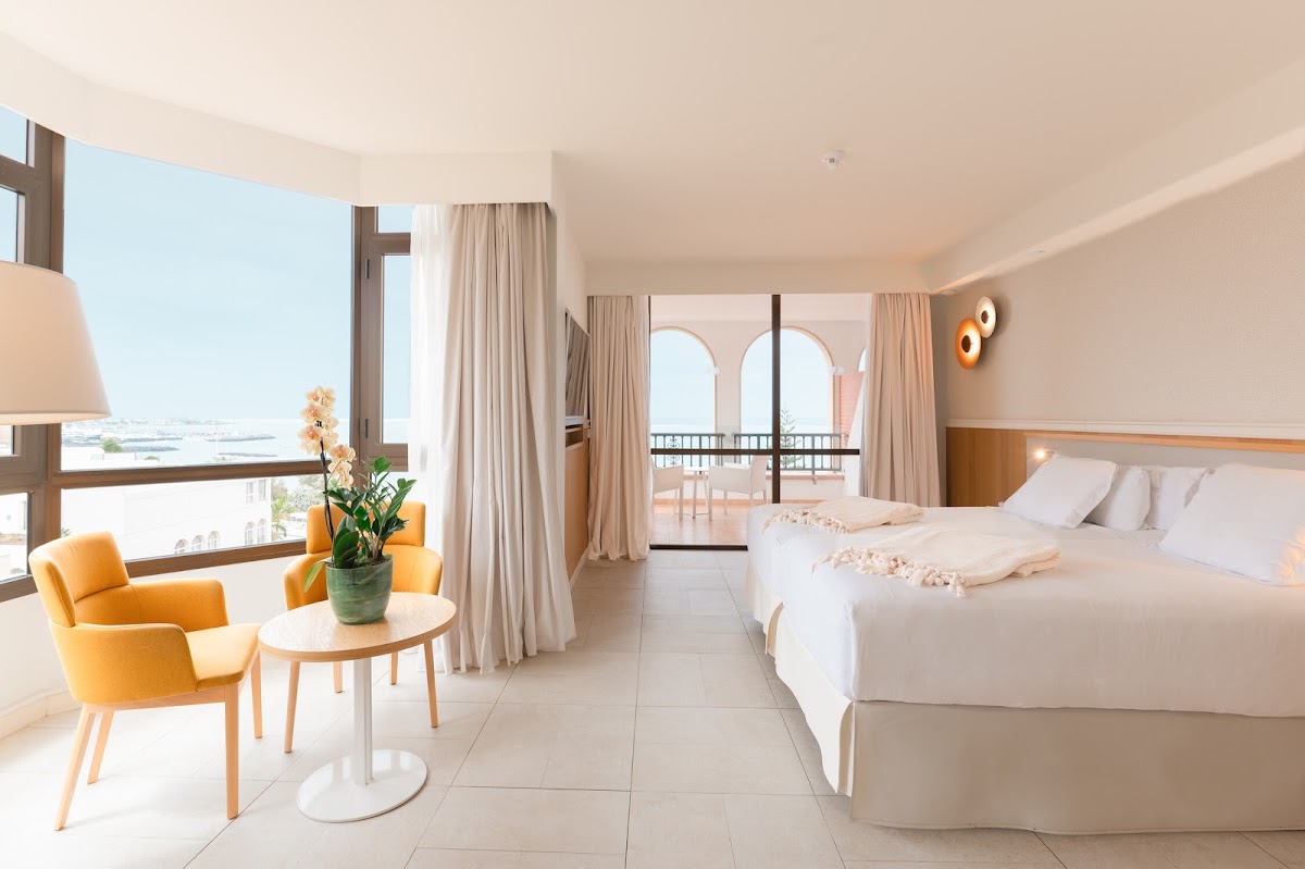 Spacious beachfront suite at Iberostar Selection Anthelia with two beds, orange chairs, and sea views from the balcony.