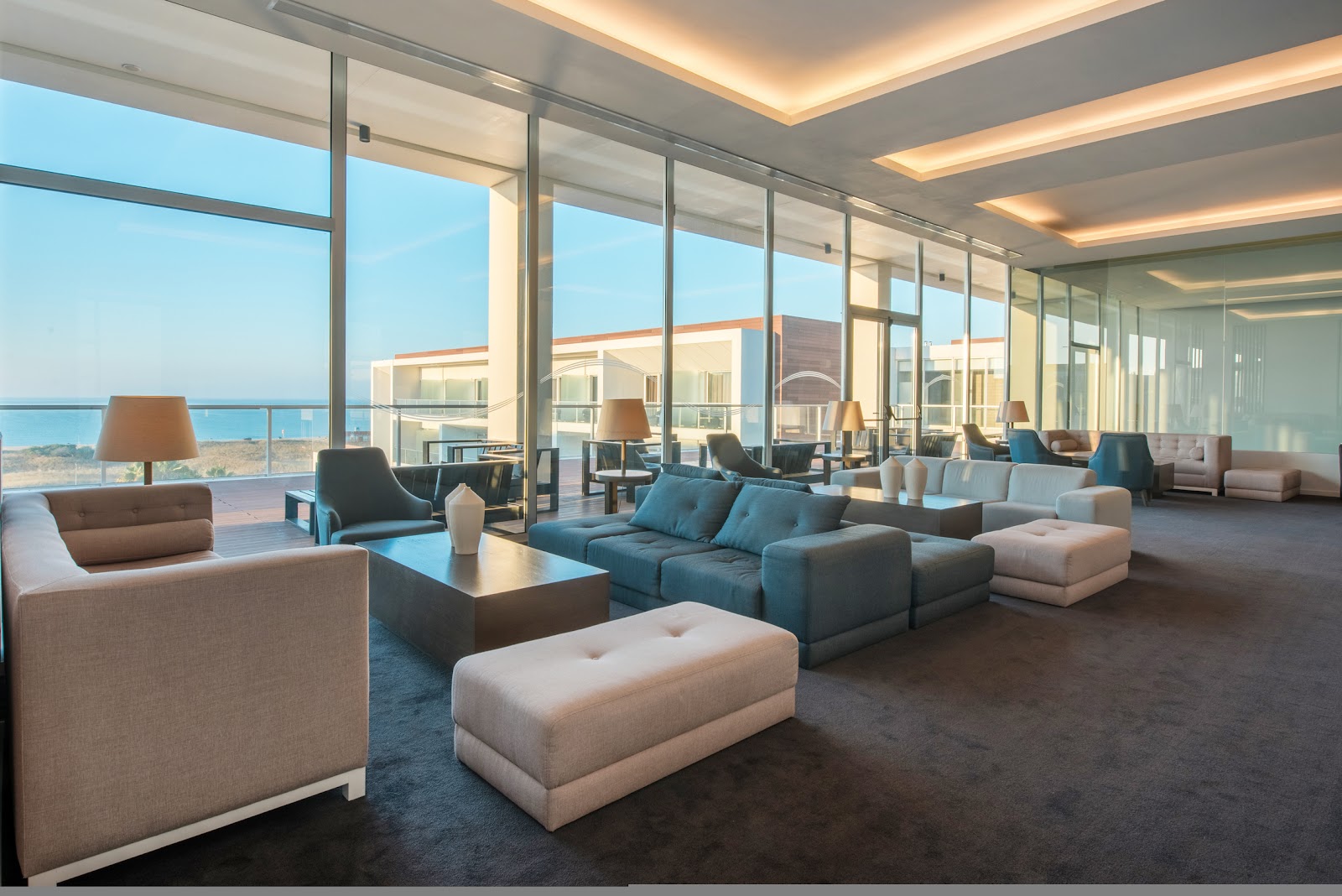 Modern buffet dining area at Iberostar Selection Lagos Algarve with multiple food stations, ocean views through floor-to-ceiling windows, and contemporary black and white cabinetry.