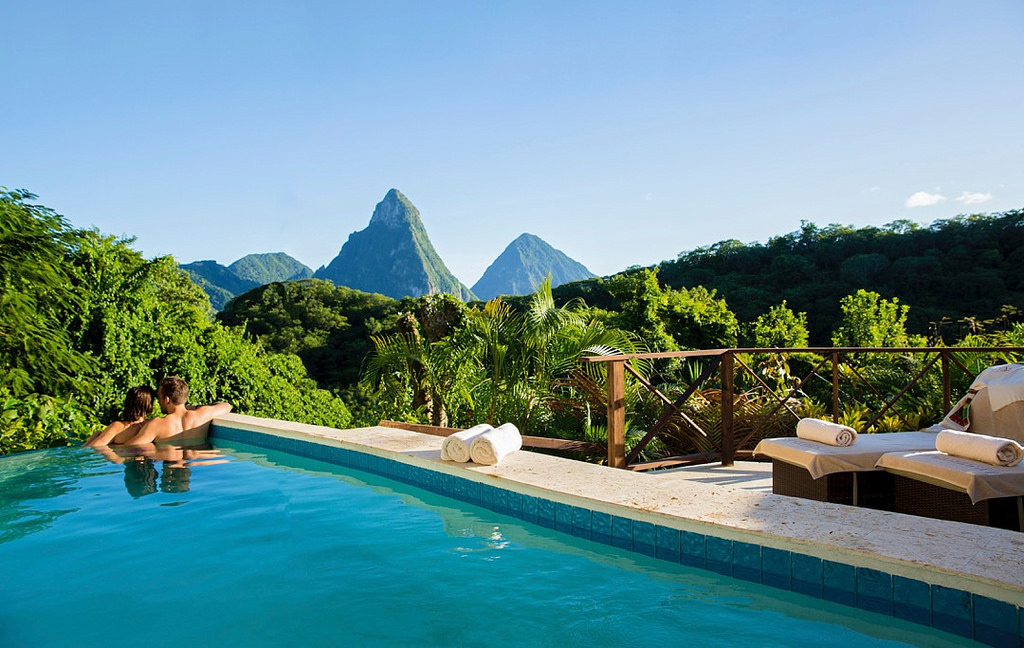 Guest swimming in infinity pool overlooking the Pitons and lush valley at Jade Mountain resort.