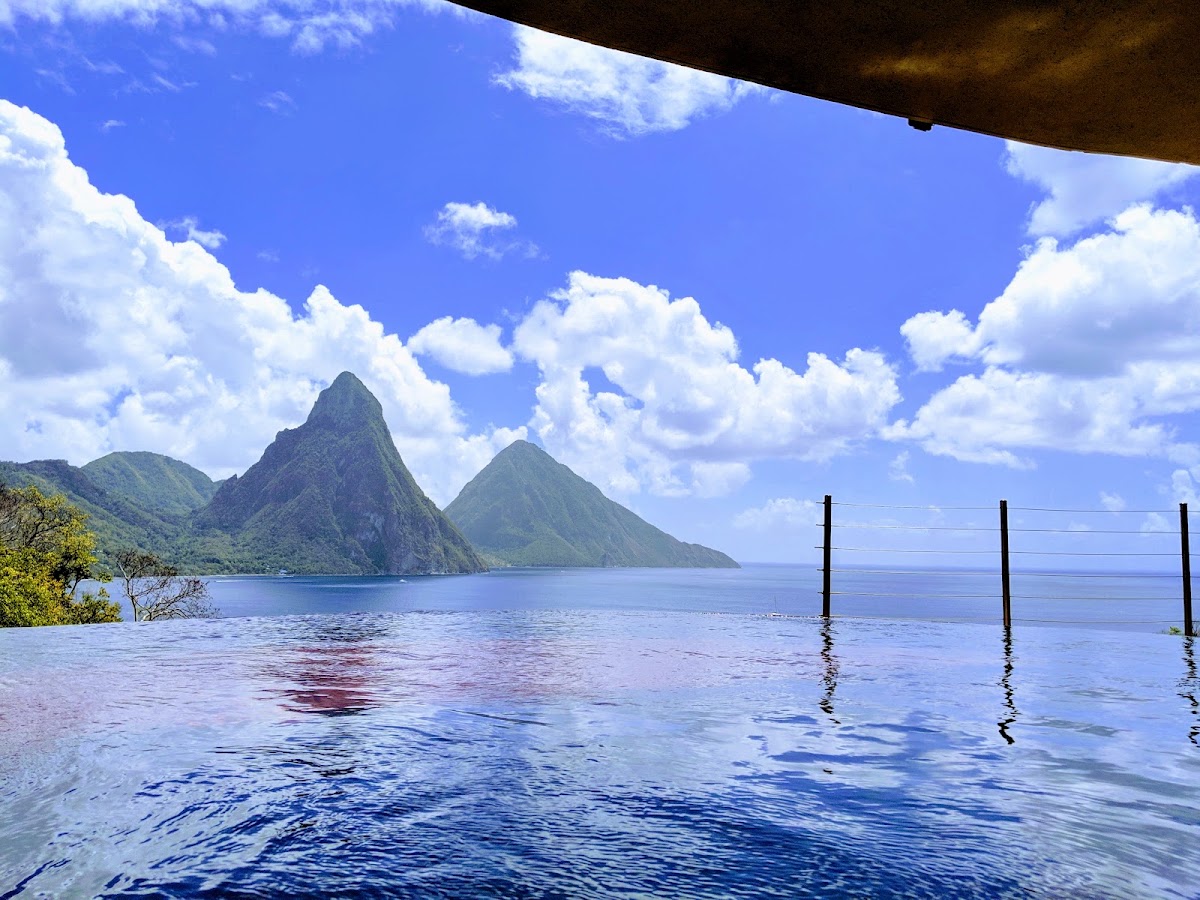 Infinity pool at Jade Mountain overlooking the Pitons and Caribbean Sea under blue sky with white clouds.
