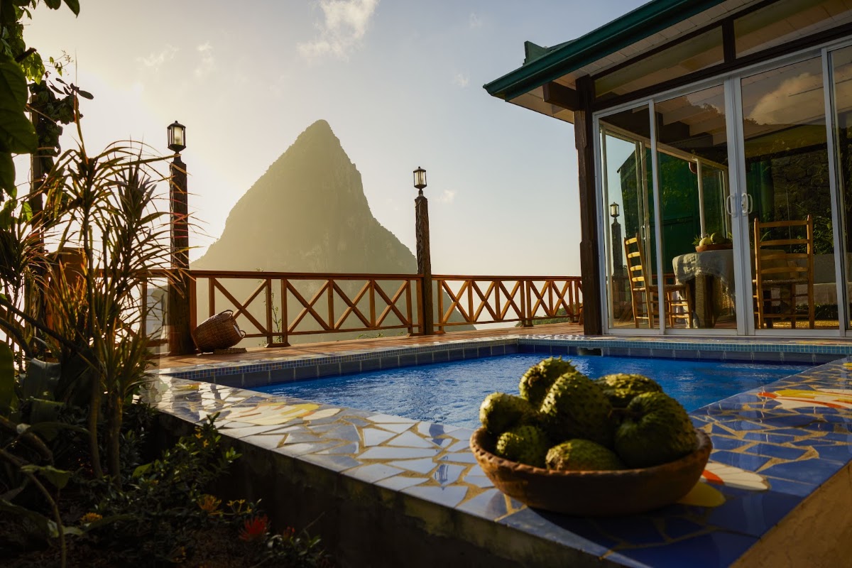 Private pool overlooking a dramatic piton mountain at Ladera Resort, with potted cactus in foreground and wooden railings framing the view.