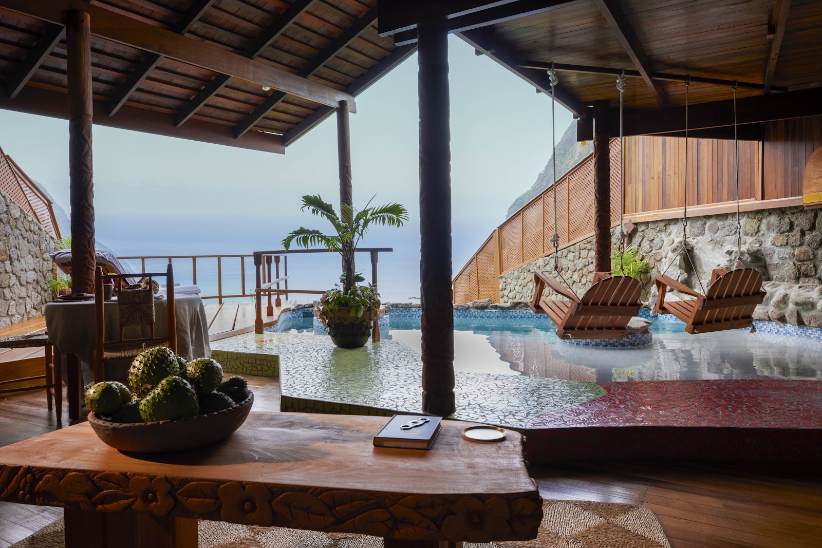 Wooden deck with cactus planter overlooking infinity pool, ocean, and Pitons at Ladera Resort.