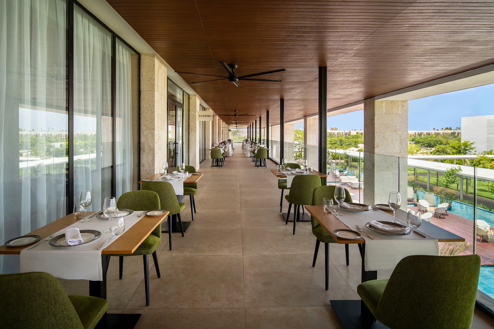 Resort suite opens to private plunge pool and patio with lounge chairs overlooking a larger pool and manicured grounds.