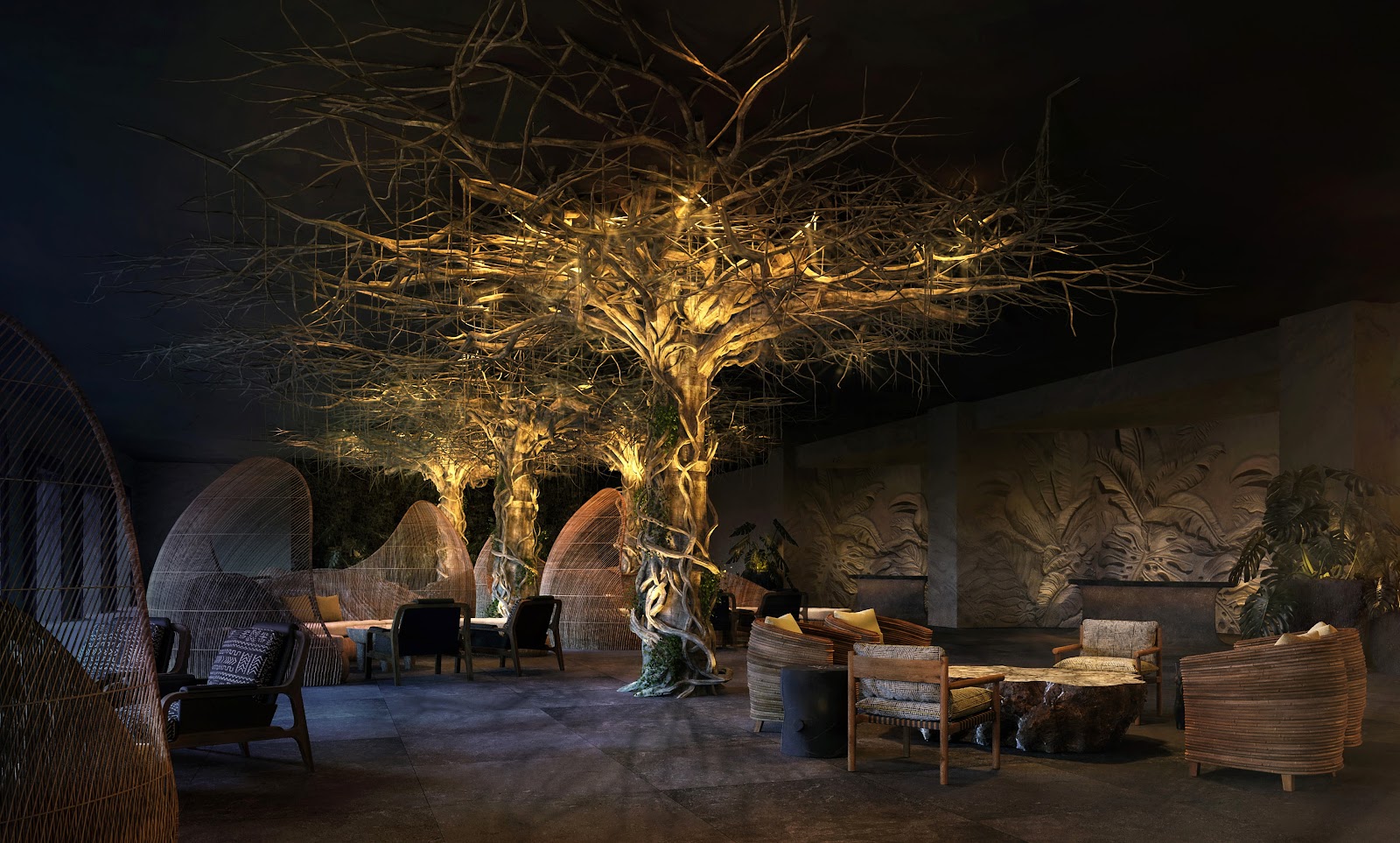 Nighttime lounge area with illuminated bare tree, woven chairs, and decorative wall reliefs at Lopesan Caoba Lagoon Resort.