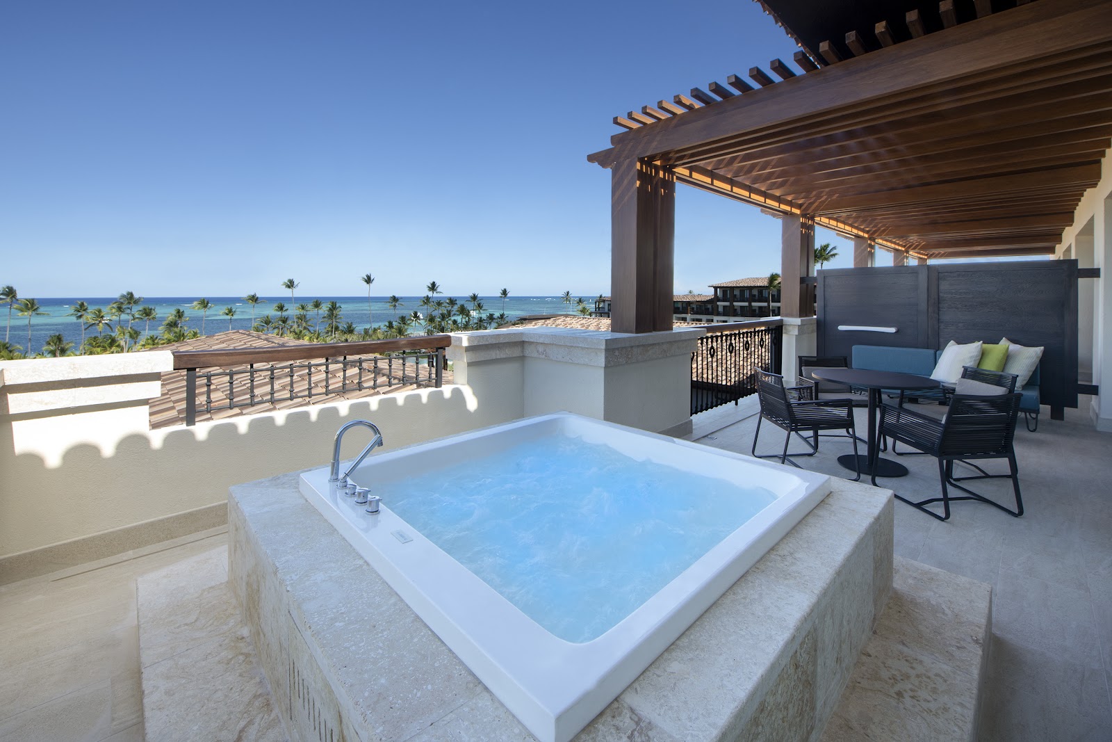 Private terrace with sunken soaking tub, lounge seating, and ocean views at Lopesan Costa Bavaro Resort.