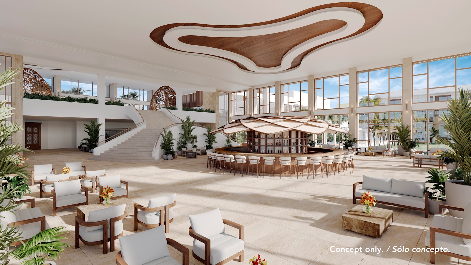 Resort balcony with woven chairs, small table with fruit bowl, ocean view, palm-lined beach, and bedroom seating area visible through glass doors.