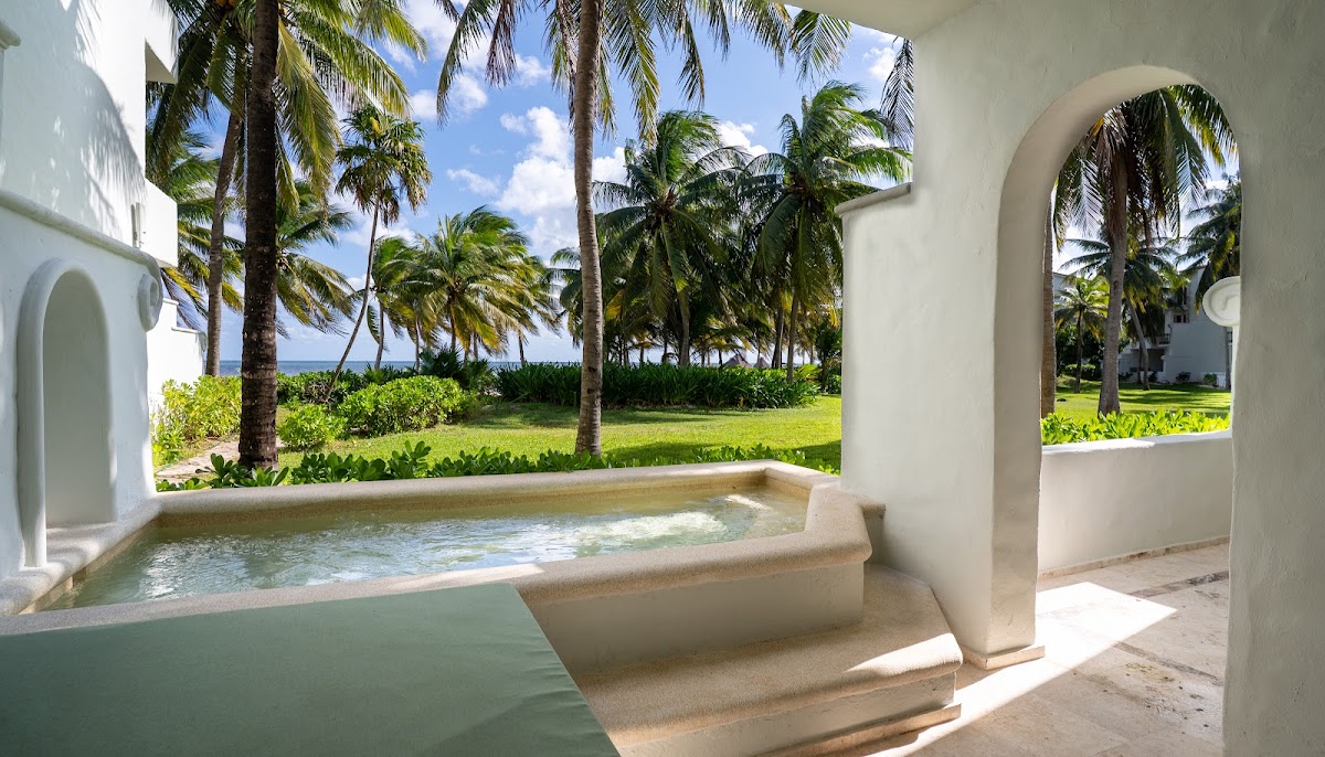 Private soaking tub on a beachfront terrace at Marriott All-Inclusive Riviera Maya, with palm trees and ocean view.