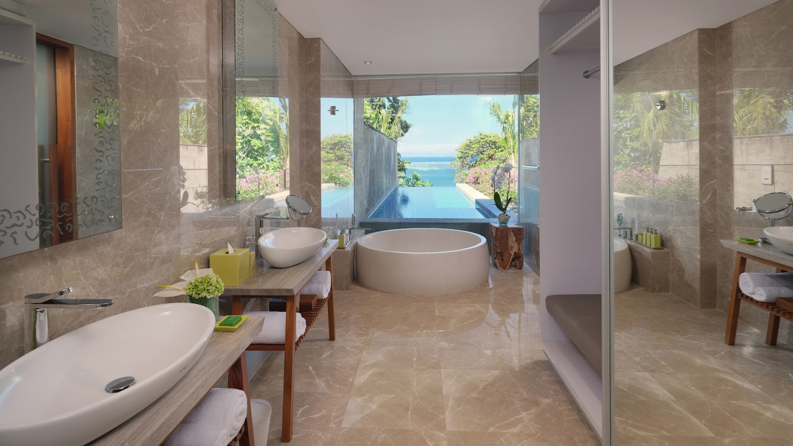 Spacious bathroom at Maya Sanur Resort & Spa with dual vessel sinks, freestanding tub, and ocean views through floor-to-ceiling windows.