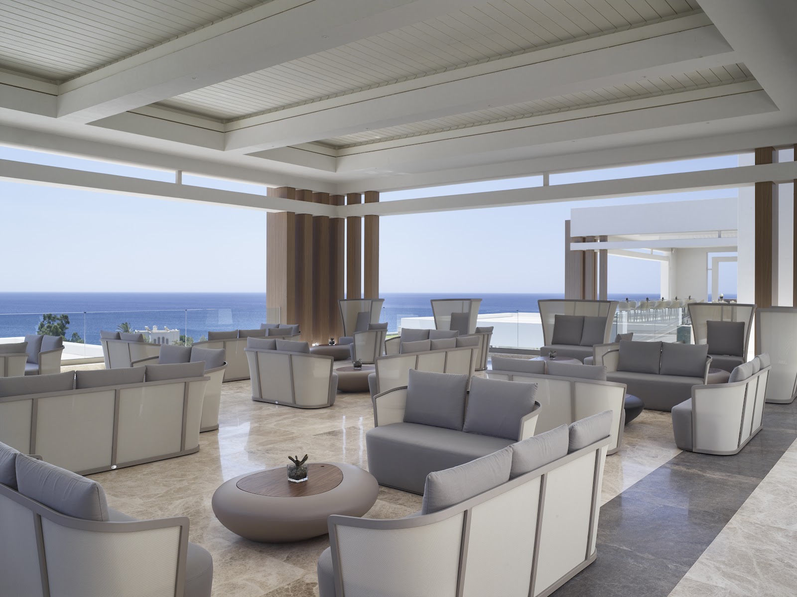 Modern restaurant dining room with wooden dome structure, cream chairs, and green wall panels at Mayia Exclusive Resort & Spa.