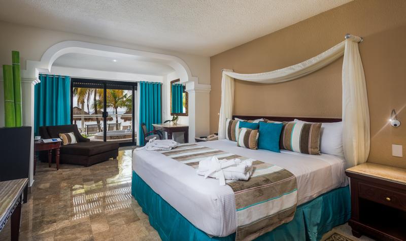 Beachfront suite at Meliá Cozumel with ocean view from balcony, bed, seating area, and flat-screen TV.