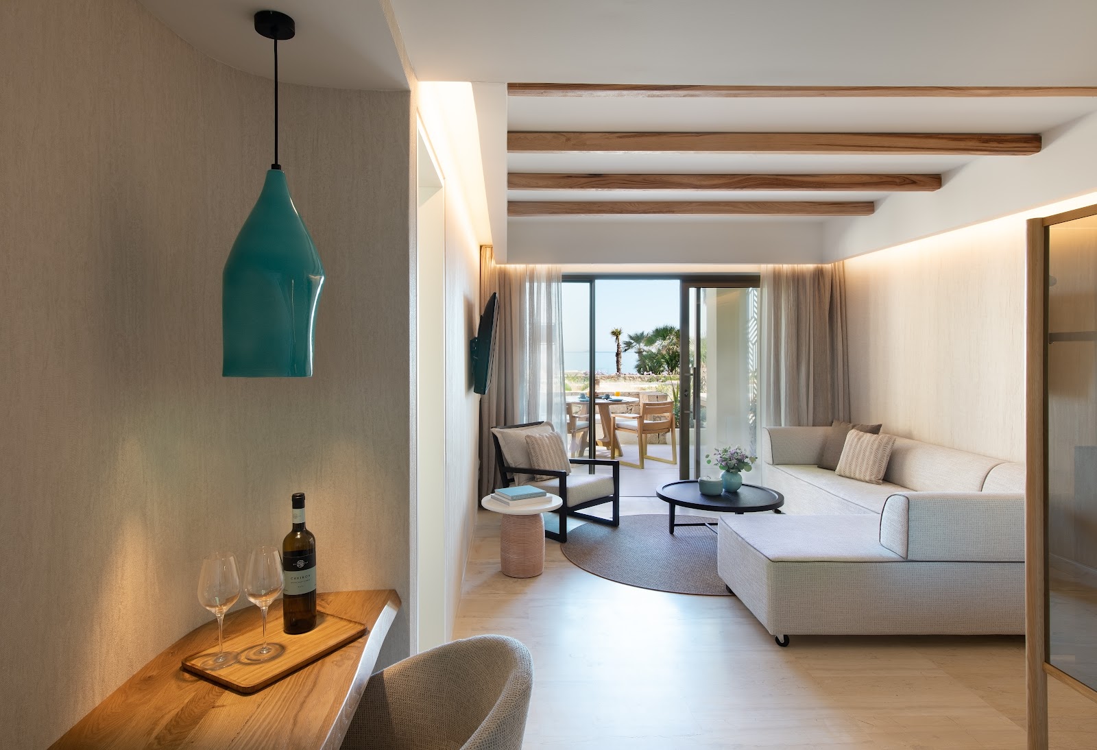 Resort bedroom with textured headboard featuring concentric geometric patterns, white bedding, two hanging pendant lights, and side tables.