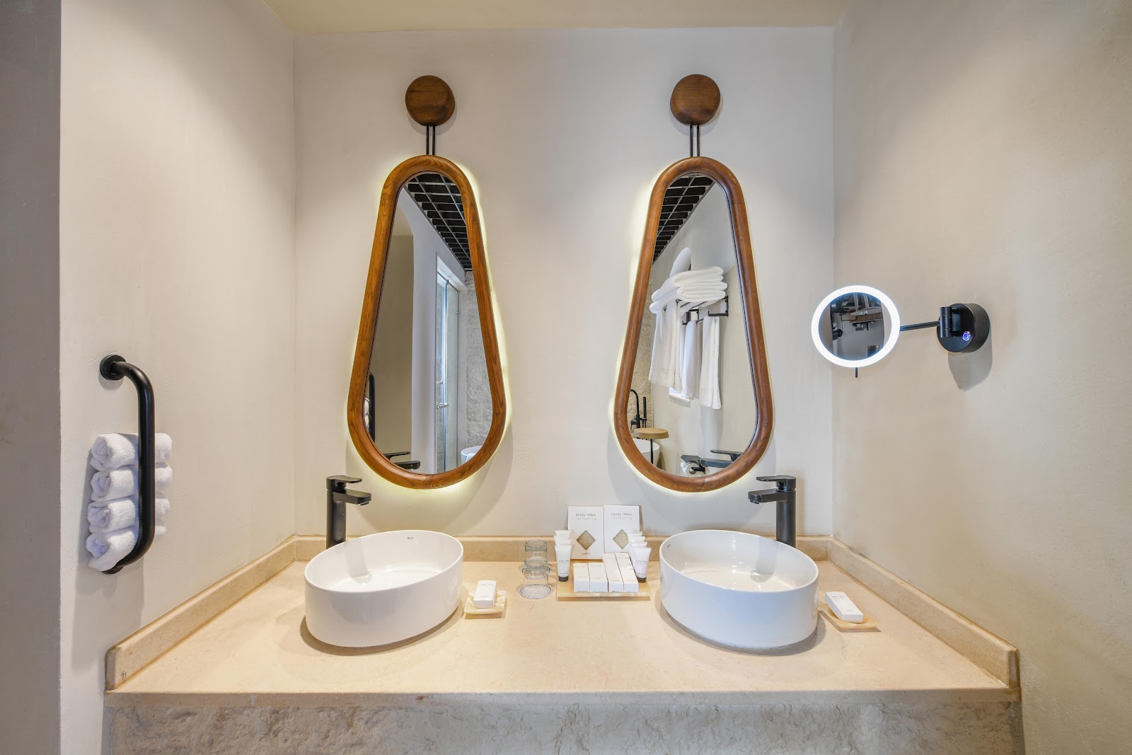 Double vanity with two white round sinks, wooden-framed mirrors, and toiletries at Movenpick Resort El Quseir.