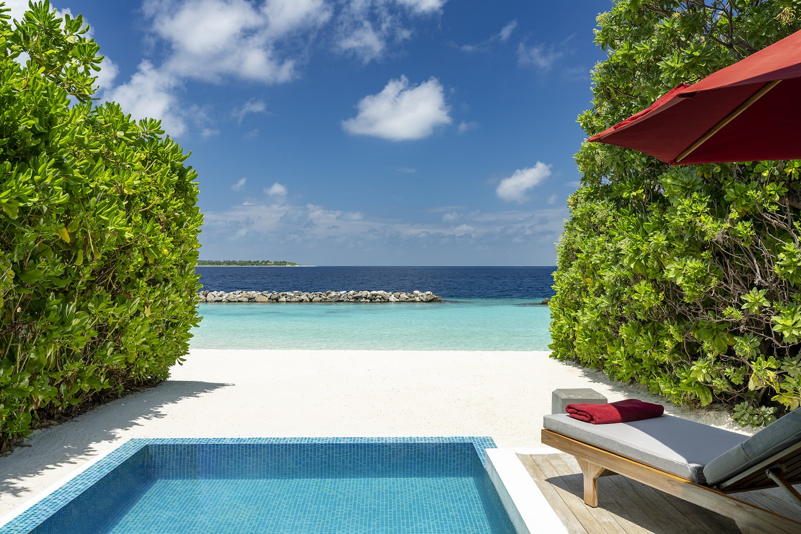 Private villa pool and beach at NIVA Dhigali Maldives, with turquoise water and white sand framed by mangrove trees.
