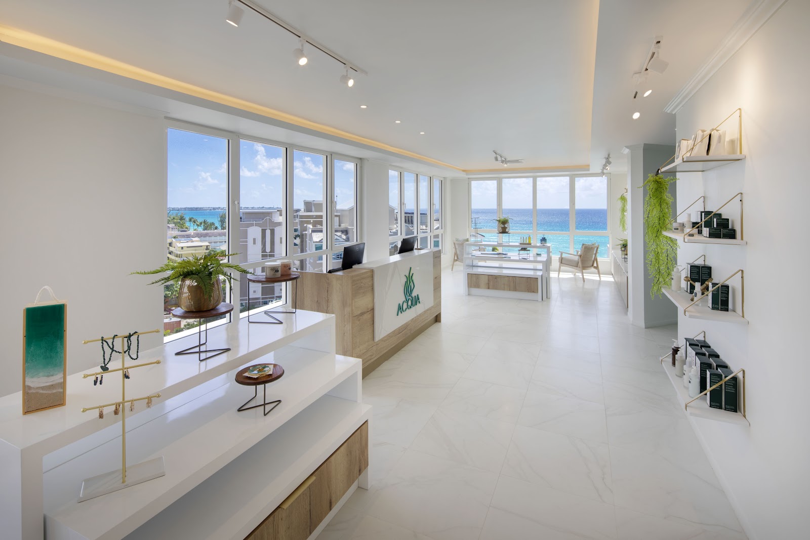 Modern spa reception area at O2 Beach Club & Spa with floor-to-ceiling windows overlooking the Caribbean Sea and resort grounds.