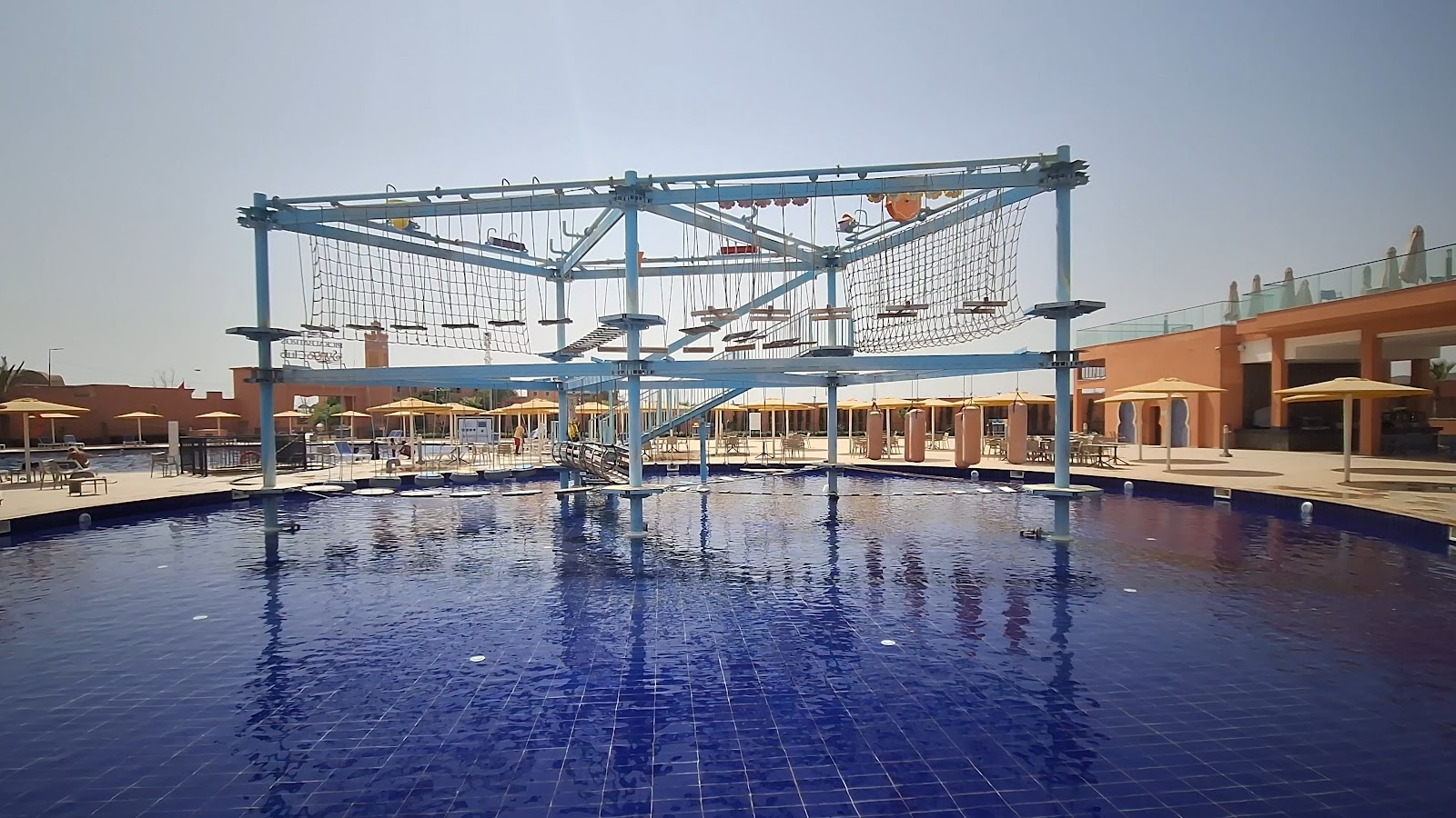 Indoor swimming pool with starry ceiling, loungers along sides, and changing rooms reflected in still water.