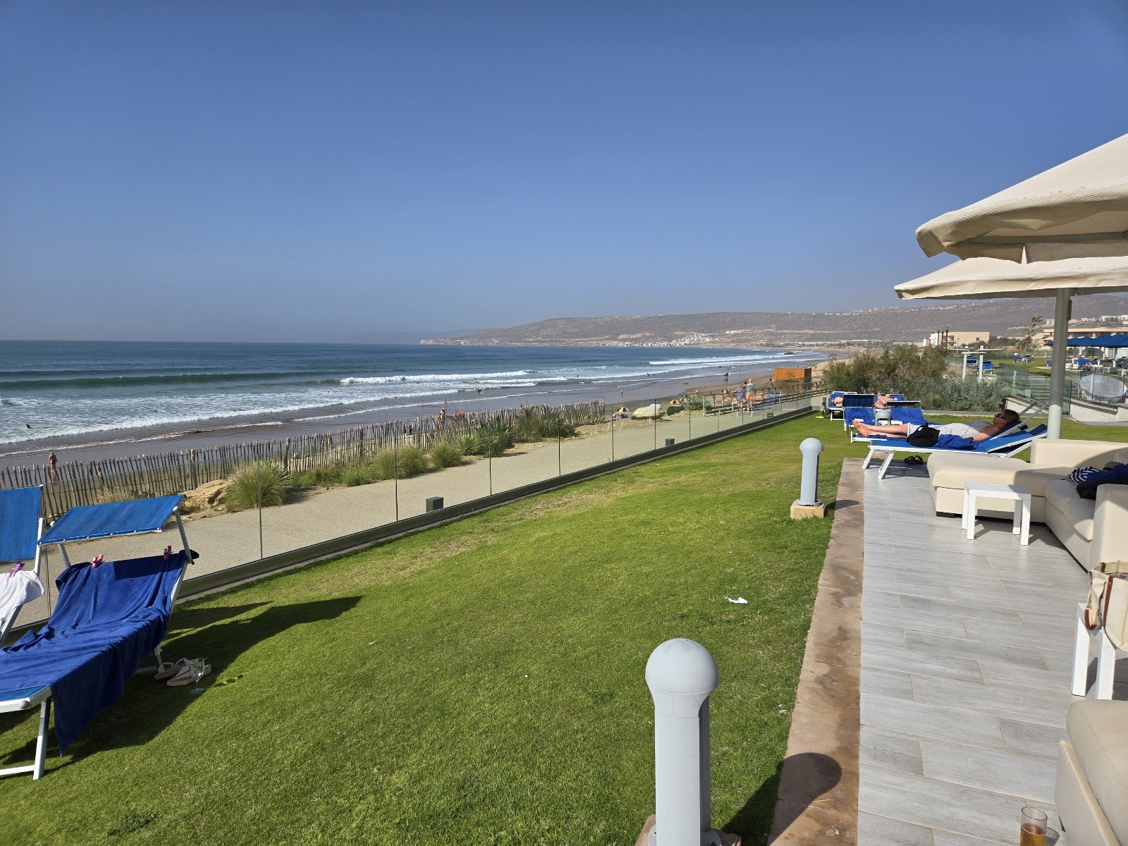 Paved walkway with reflecting pools flanked by tall palms leads toward the main swimming pool and beach at Pickalbatros White Beach Taghazout.