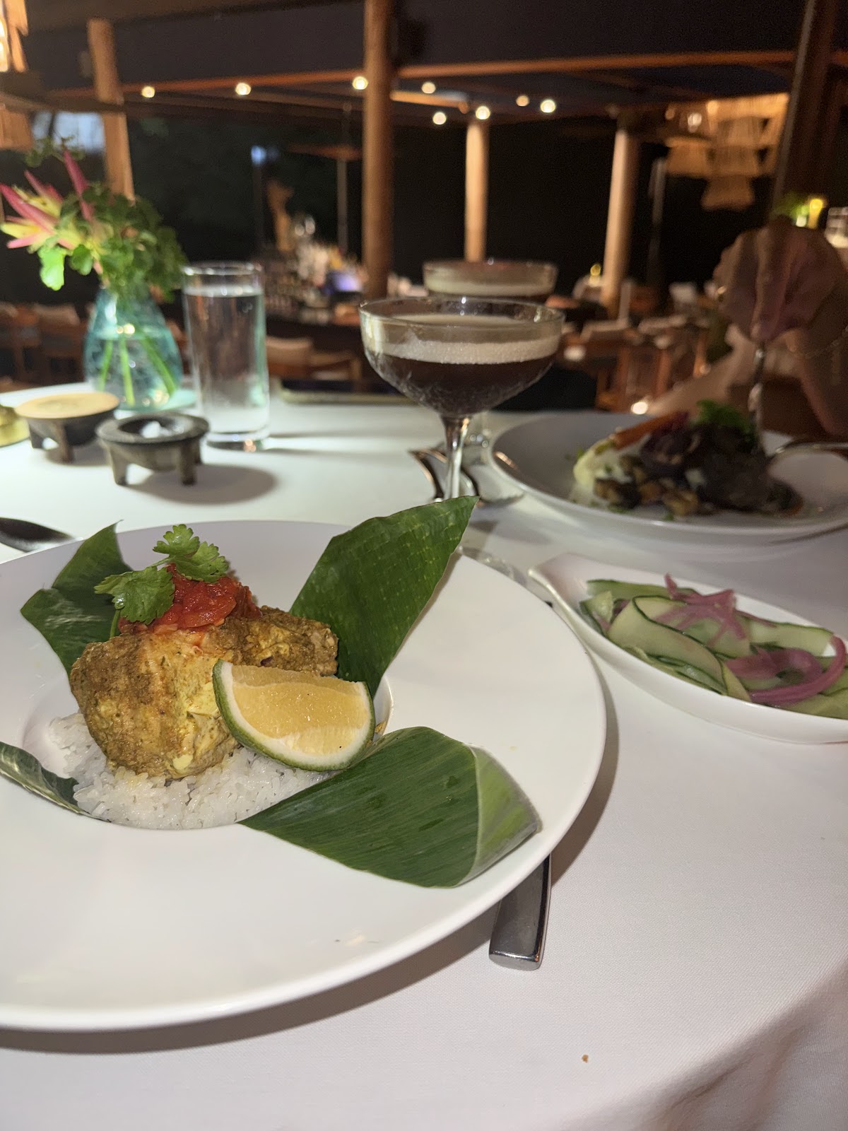 Plated crab cake with lime and garnish at an evening dining table overlooking the ocean at Royal Davui Island Resort.