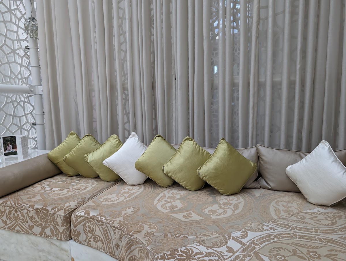 Cushioned seating with alternating gold and white pillows against sheer curtains at Royal Mansour Marrakech.