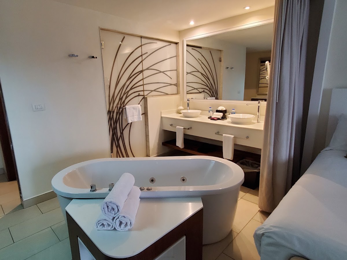 Spacious bathroom at Royalton Saint Lucia with freestanding soaking tub, dual vanity, and walk-in shower with decorative glass panel.