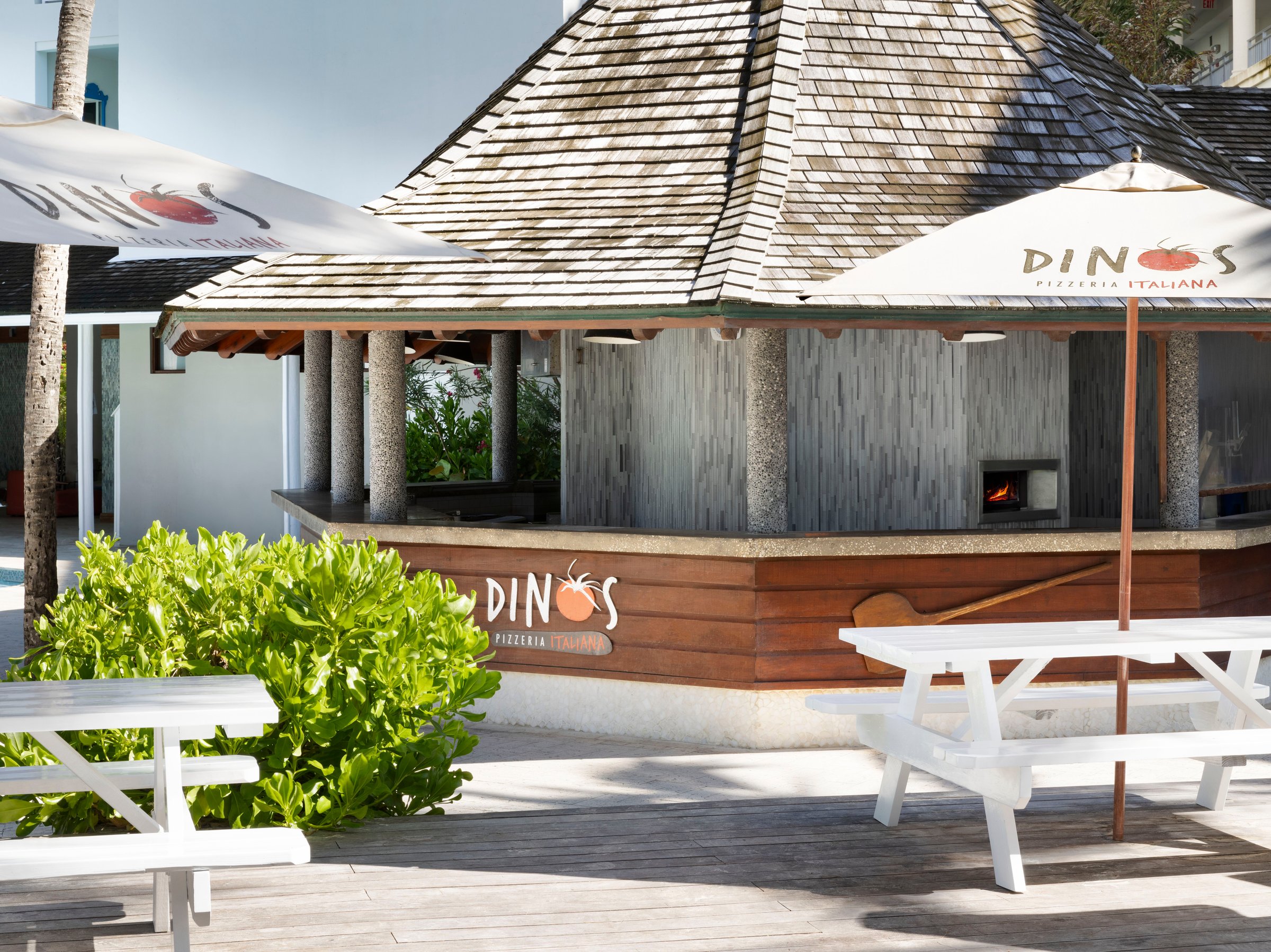Dino's pizzeria hut with a wood-fired oven and picnic tables.